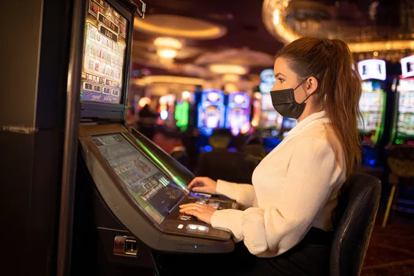 A player using their smartphone during a festive local event, representing 7D77’s fully mobile-friendly casino.